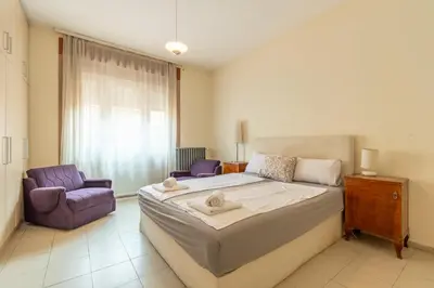 a bedroom with a large bed and two purple chairs at Apartments Terazije in Belgrade