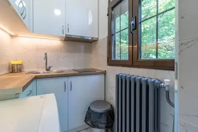a small kitchen with a radiator and a window at Apartments Terazije in Belgrade