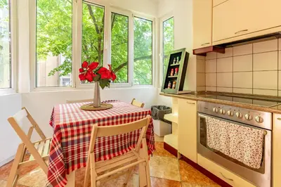 a kitchen with a table with a vase of flowers on it at Apartments Terazije in Belgrade