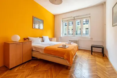 a bedroom with a bed and a yellow wall at Apartments Terazije in Belgrade