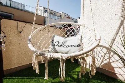 a white swinging chair with a welcome pillow on it at Sunwave with Terrace 280 Mbps Old Town Renovated in Belgrade