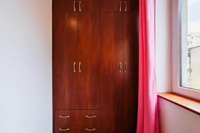 a wooden cabinet with a pink curtain next to a window at Sunwave with Terrace 280 Mbps Old Town Renovated in Belgrade