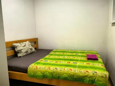 a small bedroom with a bed with a green comforter at B and S apartment 2 in Belgrade