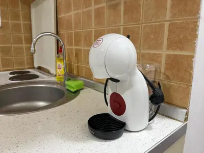 a white mixer sitting on a counter next to a sink at The Cozy George Apartment in Belgrade