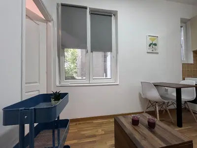 a living room with a table and a window at The Cozy George Apartment in Belgrade