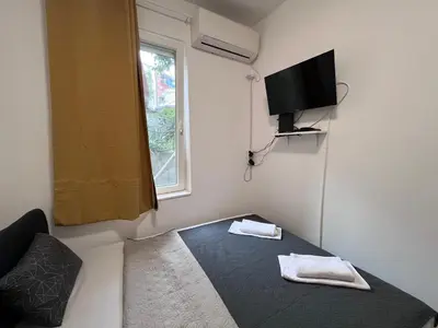 a small room with a bed and a television at The Cozy George Apartment in Belgrade