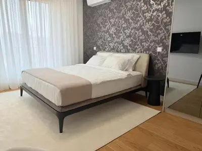 a bed in a bedroom with a wall at Landmark Premium Lux Apartment in Želenička Stanica Beograd Sava