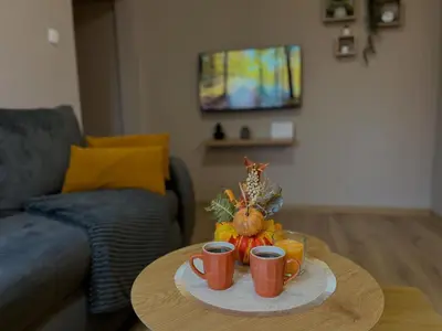 a table with two cups of coffee and a pumpkin on it at Apartman Momirov Titel
