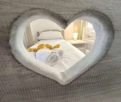 a bedroom with a heart shaped bed with towels at Apartmani Etno Selo Americ