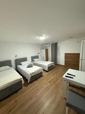 three beds in a room with wooden floors at Carigradski Drum Residence in Radinac