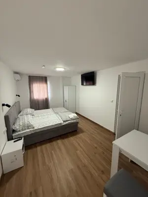 a bedroom with a bed and a wooden floor at Carigradski Drum Residence in Radinac