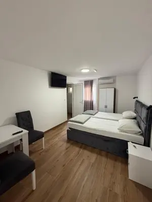 a bedroom with a bed and a desk and chairs at Carigradski Drum Residence in Radinac