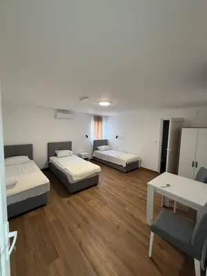 a room with three beds and a table in it at Carigradski Drum Residence in Radinac