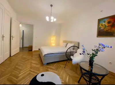 a bedroom with a bed and a table with a vase of flowers at Belgrade Apartment Dorcol in Belgrade