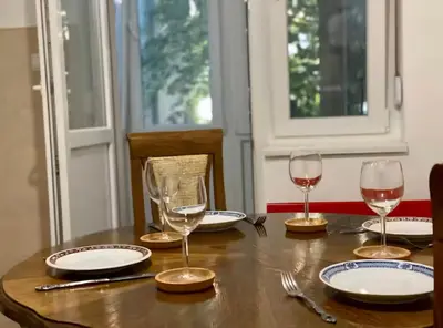 a wooden table with wine glasses and plates on it at Belgrade Apartment Dorcol in Belgrade