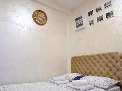 a bedroom with a bed and a clock on the wall at Apartman 11550 in Lazarevac