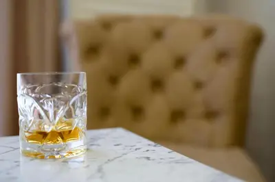 a glass of whiskey sitting on a table at Apartman 11550 in Lazarevac