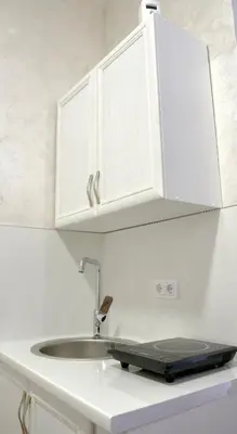 a kitchen counter with a sink and white cabinets at Apartman 11550 in Lazarevac