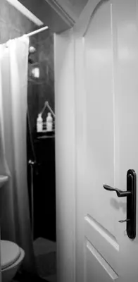 a bathroom door with a toilet and a shower at Apartman 11550 in Lazarevac