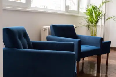 two blue chairs and a plant in a room at High White apartments 2 NEW in Belgrade