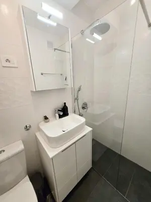 a white bathroom with a sink and a shower at High White apartments 2 NEW in Belgrade