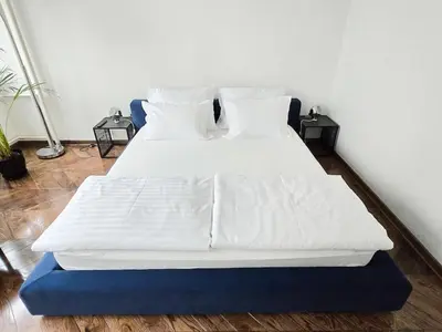 a bed with white sheets and pillows in a room at High White apartments 2 NEW in Belgrade