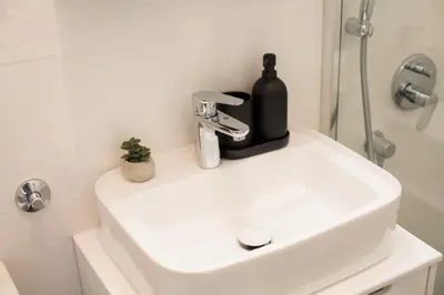 a bathroom sink with a black soap dispenser on it at High White apartments 2 NEW in Belgrade