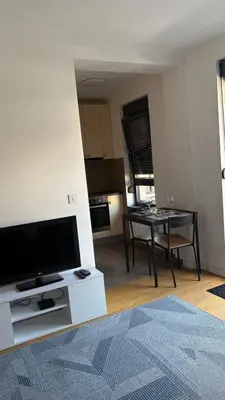 a living room with a flat screen tv and a table at Belgrade Terrace Apartment in Belgrade