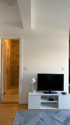 a living room with a flat screen tv on a white entertainment center at Belgrade Terrace Apartment in Belgrade