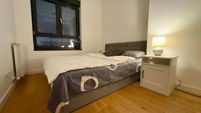 a bedroom with a bed and a table and a window at Belgrade Terrace Apartment in Belgrade