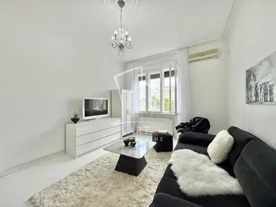 a living room with a black couch and a tv at Park Oasis Centerpoint Residence in Belgrade