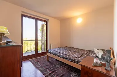 a bedroom with a bed and a large window at Kućica na brdu-Zaklopača in Zaklopača