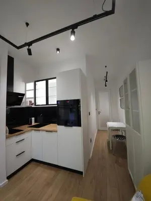 a kitchen with white cabinets and a dining room at Don apartment Dorcol in Belgrade