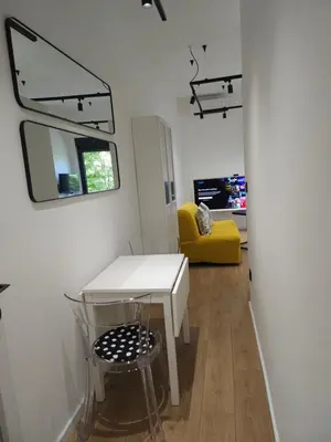 a room with a white table and a yellow chair at Don apartment Dorcol in Belgrade