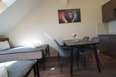 a small room with a table and chairs and a bed at Elidon 1833 in Pančevo