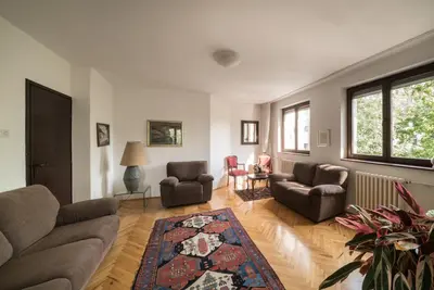 a living room with couches and chairs and a rug at Sensitive Apartment in Belgrade
