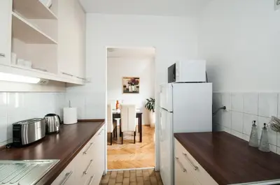 a kitchen with a white refrigerator and a table at Sensitive Apartment in Belgrade