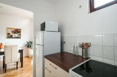 a kitchen with a white refrigerator and a table at Sensitive Apartment in Belgrade