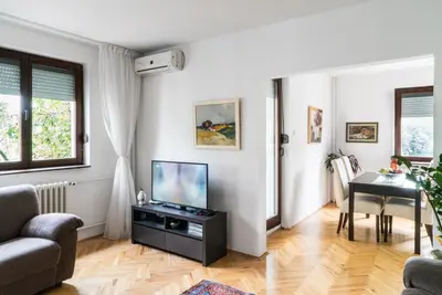 a living room with a television and a table at Sensitive Apartment in Belgrade
