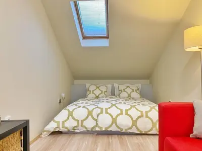 a bedroom with a bed and a red chair at Stay at Balkanska 45 in Belgrade