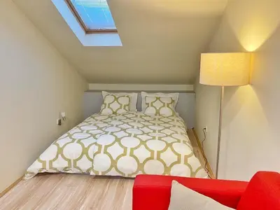 a bedroom with a bed and a red couch at Stay at Balkanska 45 in Belgrade