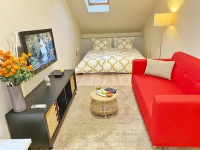 a living room with a red couch and a bed at Stay at Balkanska 45 in Belgrade