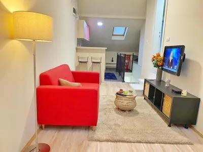 a living room with a red chair and a television at Stay at Balkanska 45 in Belgrade