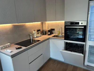 a kitchen with white cabinets and a sink and a microwave at Elmora Residence Vračar Južni Bulevar in Belgrade