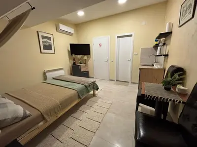 a bedroom with a bed and a desk and a tv at Elan Apartment in Belgrade