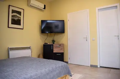 a bedroom with a bed and a tv on the wall at Elan Apartment in Belgrade