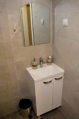 a bathroom with a white sink and a mirror at Elan Apartment in Belgrade