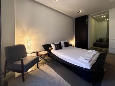 a bedroom with a bed and a chair in it at City Center Apartment in Belgrade