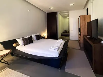 a bedroom with a large bed and a flat screen tv at City Center Apartment in Belgrade