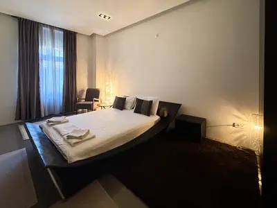a bedroom with a large bed with white sheets and pillows at City Center Apartment in Belgrade